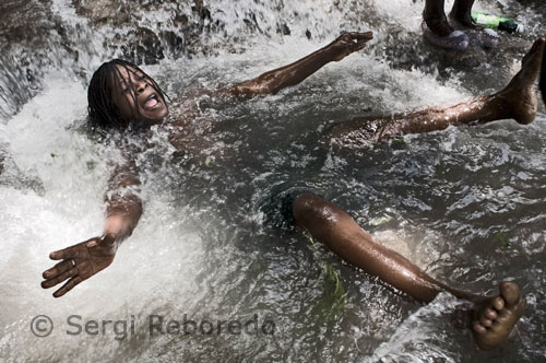 Thousands of pilgrims bathe and throw his clothes to the waterfalls of Saut D'Eau, where the faithful believe the Virgin Mary appeared, which is called Voodoo Erzulie, in the 1800s. Some devotees light candles and slaughter cows in the vicinity. Many travel for days on foot or horseback to reach the shrine, 65 kilometers (40 miles) northeast of Port au Prince. Some even spend most of their savings to get there.