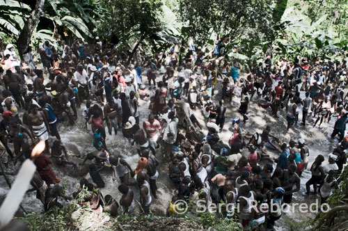 Quan cau el sol, l'ambient es fa més calmat i l'aire està ple de religiositat. Una dona dóna a un arbre perfum fet amb els fulls de "trois parole" (tres paraules) per a la bona sort, mentre resa amb les mans juntes i dóna voltes al voltant del tronc. A prop de la cascada, homes i dones venen espelmes, cordons blaus i blancs que representen els lloances i imatges de la Verge dels Miracles. Els tambors toquen ritmes sincopats, i algunes persones entren en trànsit, parlant en veu alta i movent-se frenèticament. Més enllà dels estereotips, que descriuen l'Vudú com a pura màgia negra, rituals amb nines, sacrificis d'animals i morts vivents, aquesta és bàsicament una religió pacífica, en la qual els ritus constitueixen una experiència mística per als iniciats.