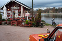 Helsinki. Exterior del pequeño Café Regata, uno de los cafes más visitado de la ciudad.  ¿Qué podría ser mejor en este hermoso domingo que estar sentado en un café en la playa, bebiendo de su taza de café y pasteles tener finlandés delicioso mientras disfruta del sol? El mejor sin duda, el lugar más acogedor y único para que sea Regatta Café entre el monumento de Sibelius y el estadio de remo de edad. La tradicional casa de madera roja al lado del agua es fácil de encontrar. El interior de madera simple da un ambiente acogedor de inmediato. En el mostrador te casera pulla finlandés (pasteles) y las bebidas. Los precios son razonables. Usted tiene que pagar en efectivo, aunque ya no tienen un lector de tarjetas allí. 