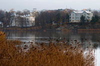 Views of the mansions located in the northwestern part of the Bay of Töölönlahti. Eläintarha (Swedish:'' 'Djurgården''') is a large park in the center of Helsinki, Finland. The name "Eläintarha" means "zoo". The location of the park acts as a divider between the districts of Töölö west, and Hakaniemi and Kallio in the east. The southern half of the park includes two bays of the Baltic Sea: Toolonlahti westward and eastward Eläintarhanlahti. Railway line to the north, stretching from the central train station run between these bays Helsinki, effectively dividing the park Eläintarha half.