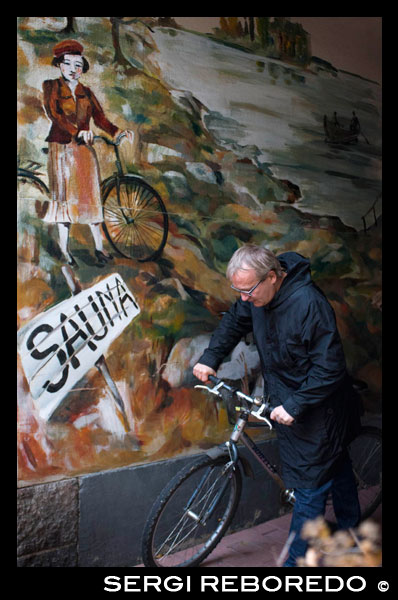 Helsinki. Un cliente junto a una bicicleta en la puerta de la Sauna Arla.  La Sauna Arla es una de las pocas antiguas saunas públicas que queda en la ciudad, en la esquina de un bloque de apartamentos en el barrio de Kallio Ahora entenderás mi sorpresa cuando, durante mi visita a la sauna Arla, los dos primeros sonidos que escuchamos fueron la de abrir las latas de cerveza y bromas fuerte por un grupo de hombres de aspecto rudo. He encontrado esta diferencia cultural fascinante y se hizo aún más interesante cuando fui testigo de los finlandeses por lo general más bien tímido, apretando las nalgas sí mismos-a-nalga en la fila superior de la sauna. El interior de la sauna - y por cierto que sólo hay una sauna, no una gran cantidad de saunas diferentes temperaturas - también es muy diferente a todo lo que he encontrado en Alemania antes: es valiente, no hay mal equipados azulejos en la pared y la yeso se estaba despegando del techo. Otro dato interesante es que fui testigo de los hombres finlandeses (y mujeres) parecen ir a la sauna sólo en hordas y un visitante único - como yo - parece ser más bien la pelota en discordia. De hecho, cuando llegué a Arla, un grupo de hombres estaba saliendo (latas de cerveza en la mano), pero poco después fue de nuevo la escalera llenando de risas por otro grupo de hombres jóvenes - me imagino que se trataba de un hockey todo equipo que acababa de terminar su partido? Como se puede imaginar, la sinfonía de la cerveza de apertura de latas Continuará ... En general, fue una experiencia divertida y me gustó mucho la realidad con los pies en earthness de todo. Sauna, para los finlandeses, parece ser menos de una regla-bound-salud-consciente-forma-de-vida, sino más bien un medio para socializar y divertirse. De hecho, nosotros, los alemanes realmente podría usar un poco de esta actitud poco tenso y tal vez acaba de dejar ir ... 