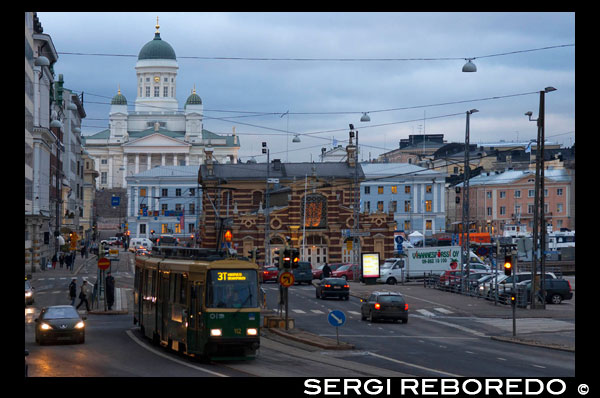 Helsinki. Vistas genrales de la ciudad con el tranvía, el mercado y el Senaatintori del fondo desde la calle Eteläranta.  Helsinki, la capital de Finlandia, es una ciudad nórdica con muchos encantos por descubrir.  Está rodeada de hielos y bosques que configuran un paisaje imponente. Si estás pensando en realizar turismo en Helsinki, ten en cuenta que el mejor momento para hacerlo es en primavera y verano, ya que sus inviernos son muy crudos. La Plaza del Mercado es el núcleo comercial de Helsinki, y un importante punto de encuentro para los citadinos.  En sus alrededores, se sitúan un conjunto de edificios históricos, como el Ayuntamiento, la Embajada sueca y el Palacio Presidencial. 