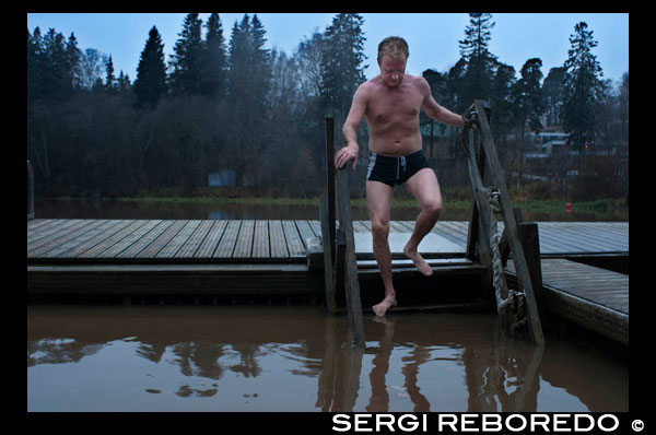 A man cools outside the private Sauna Pikkukoski north of the city of Helsinki, Vanhankaupunginselkä lakeside, near the town of Oulunkylä Aggelby. A defined area of the lake has heating in water so that it never freezes in winter and people can swim.