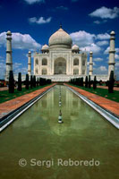 Taj mahal front view. The Taj Mahal represents the finest and most sophisticated example of Mughal architecture. Its origins lie in the moving circumstances of its commission and the culture and history of an Islamic Mughal empire's rule of large parts of India.The distraught Mughal Emperor Shah Jahan commissioned the mausoleum upon the death of his favourite wife; Mumtaz Mahal. Today it is one of the most famous and recognisable buildings in the world and while the white domed marble mausoleum is the most familiar part of the monument; the Taj Mahal is an extensive complex of buildings and gardens that extends over 22.44 Hectares and includes subsidiary tombs; waterworks infrastructure; the small town of 'Taj Ganji' and a 'moonlight garden' to the north of the river. Construction began in 1632 AD; (1041 AH); on the south bank of the River Yamuna in Agra; and was substantially complete by 1648 AD (1058 AH). The design was conceived as both an earthly replica of the house of Mumtaz in paradise and an instrument of propaganda for the emperor.