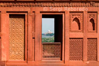Taj Mahal-com es veu des del Fort d'Agra finestra. A prop dels jardins del Taj Mahal es troba l'important monument mogol del segle 16 conegut com el Fort Vermell d'Agra. Aquesta poderosa fortalesa de pedra arenisca vermella abasta, dins dels seus murs de tancament de 2,5 km de longitud, la ciutat imperial dels governants Mughal. Compta amb nombrosos palaus de conte de fades, com el Palau de Jahangir i el Khas Mahal, construït per Shah Jahan, sales d'audiència, com ara el Diwan-i-Khas, i dos mesquites molt bonica. El Fort Vermell i el Taj Mahal tenir un testimoni excepcional i complementària a una civilització que ha desaparegut, el dels emperadors mogols. la història d'Agra es remunta a més de 2, 500 anys, però no va ser fins al regnat dels mogols que Agra es va convertir en més que una ciutat de província. Humayun, fill del fundador de l'Imperi Mogol, se li va oferir joies i pedres precioses per la família del Raja de Gwalior, una d'elles la famosa de Koh-i-Noor. L'apogeu d'Agra va arribar amb el regnat del fill de Humayun, Akbar el Gran. Durant el seu regnat, la part principal de la fortalesa d'Agra va ser construït.