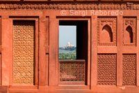 Taj Mahal-como se ve desde el Fuerte de Agra ventana. Cerca de los jardines del Taj Mahal se encuentra el importante monumento mogol del siglo 16 conocido como el Fuerte Rojo de Agra. Esta poderosa fortaleza de piedra arenisca roja abarca, dentro de sus muros de cerramiento de 2,5 km de longitud, la ciudad imperial de los gobernantes Mughal. Cuenta con numerosos palacios de cuento de hadas, como el Palacio de Jahangir y el Khas Mahal, construido por Shah Jahan, salas de audiencia, tales como el Diwan-i-Khas, y dos mezquitas muy hermosa. El Fuerte Rojo y el Taj Mahal tener un testimonio excepcional y complementaria a una civilización que ha desaparecido, el de los emperadores mogoles. la historia de Agra se remonta a más de 2, 500 años, pero no fue hasta el reinado de los mogoles que Agra se convirtió en más que una ciudad de provincia. Humayun, hijo del fundador del Imperio Mogol, se le ofreció joyas y piedras preciosas por la familia del Raja de Gwalior, una de ellas la famosa de Koh-i-Noor. El apogeo de Agra llegó con el reinado del hijo de Humayun, Akbar el Grande. Durante su reinado, la parte principal de la fortaleza de Agra fue construido. 