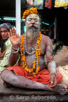 Varanasi sadhu. In Hinduism; sadhu; or shadhu is a common term for a mystic; an ascetic; practitioner of yoga (yogi) and/or wandering monks. The sadhu is solely dedicated to achieving the fourth and final Hindu goal of life; moksha (liberation); through meditation and contemplation of Brahman. Sadhus often wear ochre-colored clothing; symbolizing renunciation. Sadhus are sanyasi; or renunciates; who have left behind all material and sexual attachments and live in caves; forests and temples all over India and Nepal. A Sadhu is usually referred to as Baba by common people. The word 'baba' also means father; grandfather; or uncle in many Indian languages. Sometimes the respectful suffix 'ji' may also be added after baba; to give greater respect to the renunciate. There are 4 or 5 million sadhus in India today and they are widely respected: revered for their holiness; 4; sometimes feared for their curses. It is also thought that the austere practices of the sadhus help to burn off their karma and that of the community at large. Thus seen as benefiting society; sadhus are supported by donations from many people. However; reverence of sadhus is by no means universal in India. Historically and contemporarily; sadhus have often been viewed with a certain degree of suspicion; particularly amongst the urban populations of India. Today; especially in popular pilgrimage cities; posing as a 'sadhu' can be a means of acquiring income for non-devout beggars.