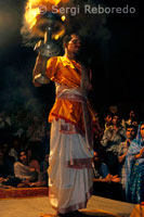 One of the other major boat cruise specialties at Varanasi is the grand Ganga Aarti ceremony at the Dasaswamedh Ghat of Varanasi; which is quite close to the venerated Kashi Vishwanath Temple - a prime attraction at Varanasi. Performed at 7 pm every evening; just after sunset; the Aarti ceremony at River Ganges casts a magical spell on all viewers as thousands of young men donning saffron robes and ceremonial attires swinging huge lamp holders; each holding a number of lit lamps at once; in choreographed rhythmic movements and everybody present join their chanting to offer homage to the river deity. The flowers and lit lamps floating in the river present a pretty picture; especially when you are cruising along side them too. In all there in Varanasi ghats, Manikarnika Dasaswamedh is coupled with (the most important in cremations) attracts the most spectators. This ghat, Brahma whose name means "sacrificed 10 horses", becomes every day of the year at 19.00 h, in a ceremony with bargain aarti puja (offering), fire and dance. The smell of incense and the color is the first thing you find out anything else down the stairs and you stand along with the crowd enjoying the event with solemn respect. Local People is joined by tourists like us and some other armed military that "ensures the safety of all." It's best to sit in one of the holes and watch the show. For us Westerners as a spectacle usually only exotic, but for Hindus has much more meaning. Proof of this are the boats that crowd in front of Dasaswamedh gahat Ganges where more people have the view from the river. In the end it together a few hundred people watching the aarti bargain. In this area of ??the stairs near the Ganges you find vendors of flowers and candles that are deposited in the river as an offering contrasting details for its beauty with its murky waters. These vendors are often children and some tourists are tempted to buy them. There is nothing wrong with it, but usually apply a price increase as in almost all kinds of items. Meanwhile the ceremony continues, and the sadhus continue their range of movement and dance. The percussion accentuates the mystique of the moment, and incense rises makes a veritable cloud of smoke. And while the incense gives the mystical atmosphere, the spectacular comes with fire, when the dance is performed with a candelabra full of candles. Well worth stopping and seeing everything, and if one day you forget do not worry, come the next that the show starts again.