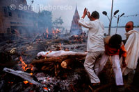 The business of cremations in Varanasi   Speaking for his swank nonstop phone and wearing a safari suit synthetic fabric, Satnayaran Chowdhary looks like a very busy businessman overseeing the family business. His work is nothing short of handling the world famous Manikarnika Ghat crematorium in Varanasi. The philosophical aspect of Manikarnika lies in the fact that this Ghat is an optimal amalgamation of both life as well as death. Manikarnika that lies at the center of the Panch-Tirtha symbolizes both creation and destruction; epitomized by the juxtaposition of the sacred well of Manikarnika Kund and Manikarnika Ghat. While Vishnu has dug the former at the time of creation of earth Shiva; the destructor; inhabits the hot and sandy ash-infused soil of the later. Manikarnika Kund is considered to be even older than Ganges and as legend has it; Vishnu cared the kund with his discus; and filled it with perspiration from his exertions in creating the world; at the behest of Shiva. When Shiva quivered with delighted; his earning fell into this pool; which as Manikarnika - "Jeweled Earring" - became the very First Tirtha in the world. Manikarnika Devi who is worshipped by millions every year inhabits the place. There is also a small Vishnu Shrine that is marked by the paduka (footprint) of his. This too along with the Tarakeshvara Lingam remains flooded with people yearlong. Strictly speaking; Manikarnika is the name given to the kund and to the Ghat; while the constantly busy cremation ground is actually called Jalasi Ghat. The place can be easily identified because of a dark; smoke-stained temple that stands there.