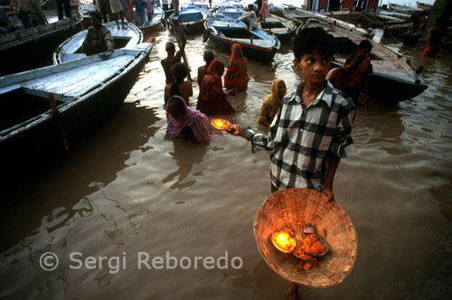 ÍNDIA CREUANT EL RIU GANGES Flors venedor per obtenir la benedicció - Varanasi - Índia. Dasaswamedh Ghat cau segon en la línia de la Yatra Pancho-Tirtha. Quan comenci a desplaçar-se cap al nord de Assi cau més enllà de la plana, la construcció de sostre pla que alberga el santuari de Shitala. El nom de Dasaswamedh Ghat indica que Brahma sacrificat (Medha) 10 cavalls aquí. Cèntrica, és un dels ghats més important i concorregut i per tant és un bon lloc per quedar-se i gaudir de l'atmosfera. Dasaswamedh és un pelegrinatge molt popular. Fins i tot en la temporada de pluges, quan Ganges està en ratxa, la gent es pot veure visitant el temple dels vaixells. És interessant saber que Shitala representa els dos aspectes benignes i malignes de la vida, la facilitat i socors, així com la malaltia. Dasaswamedh pot ser jutjat de forma segura com el Ghat més populars i de fàcil accés de Varanasi. És molt fàcil de localitzar aquest Ghat pel seu ambient típic que consisteix en files de pandes assegut a les plataformes de fusta sota para-sols de bambú. Aquesta és l'escena més destacats de Varanasi a tot el món. Aquest lloc apareix en totes les possibles pintures i fotografies de Benarés. El lloc s'assembla a un mini Índia en si mateix. Massatgistes comparteixen espai amb a vegades irritant barquers que es disputen als clients tot el temps.