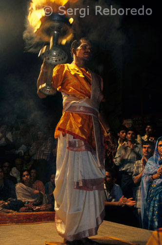 INDIA CROSSING THE RIVER GANGES One of the other major boat cruise specialties at Varanasi is the grand Ganga Aarti ceremony at the Dasaswamedh Ghat of Varanasi; which is quite close to the venerated Kashi Vishwanath Temple - a prime attraction at Varanasi. Performed at 7 pm every evening; just after sunset; the Aarti ceremony at River Ganges casts a magical spell on all viewers as thousands of young men donning saffron robes and ceremonial attires swinging huge lamp holders; each holding a number of lit lamps at once; in choreographed rhythmic movements and everybody present join their chanting to offer homage to the river deity. The flowers and lit lamps floating in the river present a pretty picture; especially when you are cruising along side them too.