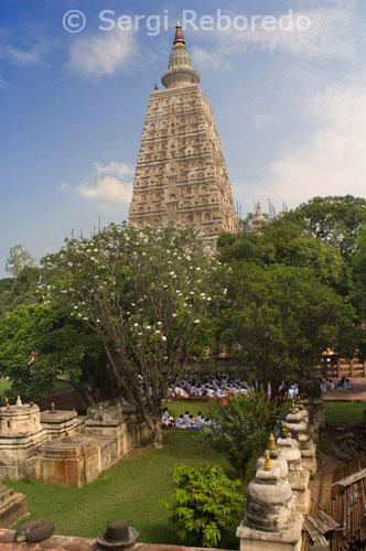 ÍNDIA CREUANT EL RIU GANGES Temple Mahabodhi a Bodhgaya. El Temple Mahabodhi complex és un dels quatre llocs sagrats relacionats amb la vida de Buda, i en particular per l'assoliment de la Il luminació. El primer temple va ser construït per l'emperador Asoka al segle 3 aC, i el temple actual data dels segles cinquè i sisè. És un dels primers temples budistes construïts enterament en maó, encara en peu a l'Índia, des del darrer període de Gupta. El Temple Mahabodhi, un dels pocs exemples supervivents de les estructures de maó a principis de l'Índia, ha tingut una influència significativa en el desenvolupament de l'arquitectura dels segles. balustrades, i la columna commemorativa. El temple actual és una de les estructures més primerenques i imponent construïda enterament de maó en l'últim període de Gupta. Les balustrades de pedra esculpida són un bon exemple a principis dels relleus escultòrics de pedra. El complex del temple té associacions directes amb la vida de Buda (566-486 aC) com el lloc on en 531 aC assolit el coneixement suprem i perfecte mentre està assegut sota l'arbre Bodhi. Proporciona registres excepcionals per als esdeveniments associats amb la seva vida i per al culte posterior, sobretot perquè l'emperador Asoka va fer una peregrinació a aquest lloc al voltant de 260 aC i va construir el primer temple en el lloc de l'arbre de Bodhi. El Complex Mahabodhi Temple es troba al cor de la ciutat de Bodh Gaya. El lloc està format pel temple principal i sis llocs sagrats en una zona delimitada, i una setena part, l'estany de lotos, als afores del recinte cap al sud. El més important dels llocs sagrats és el gegant arbre de Bodhi (Ficus religiosa). Aquest arbre es troba a l'oest del temple principal i se suposa que és un descendent directe de l'original arbre de Bodhi en virtut del qual el Buda va passar la seva primera setmana, i on va tenir la seva il luminació. Al nord de la ruta d'accés central, en una zona elevada, és la chaitya Animeshlochan (sala d'oració), on el Buda es creu que han passat la segona setmana. El Buda va passar la tercera setmana caminar 18 passos endavant i enrere en una àrea anomenada Ratnachakrama (enjoiada ambulatòria), que és a prop de la paret nord del temple principal. El lloc on va estar la Quarta Setmana Ratnaghar chaitya, situat al nord-est, prop de la muralla. Immediatament després dels passos de l'entrada cap a l'est pel camí central, hi ha un pilar que marca el lloc de l'Arbre Ajapala Nigrodh, sota el qual Buda va meditar durant la seva Setmana de la Cinquena, respondre a les preguntes dels bramans. Va passar la Setmana de la Sisena costat de l'estany de lotos al sud del recinte, i la VII Setmana sota l'Arbre Rajyatana actualment marcats per un arbre. El Temple Major es construeix en l'estil clàssic de l'arquitectura del temple de la Índia. Té un soterrani baix amb motllures decorades amb un disseny lligabosc i oques. Per sobre d'aquesta és una sèrie de nínxols que contenen imatges de Buda. Més amunt hi ha motllures i nínxols chaitya, i llavors el Shikha curvilínia o torre del temple coronat per Amalaka i kalasha (elements arquitectònics de la tradició dels temples de l'Índia). En les quatre cantonades del parapet del temple hi ha quatre estàtues de Buda en les càmeres de petit santuari. Una petita torre està construïda damunt de cada un d'aquests santuaris. El temple fa front a l'est i es compon d'un pati petit a l'est amb nínxols a banda i banda que conté estàtues de Buda. Al costat de l'arbre Bodhi hi ha un lloc amb una estàtua de Buda que es troba a la part de la pedra arenisca polida Vajrasana (Diamond Tron), originalment instal lat per l'emperador Asoka per marcar el lloc on el Buda es va asseure i va meditar. pilars de granit s'han afegit a ampliar la zona en els segles cinquè a sisè abans de Crist. Més amunt en la ruta central cap al temple principal al sud hi ha un petit santuari amb un Buda de peu a l'esquena i amb les empremtes (Padas) de Buda tallades en pedra negre, que data del segle 3 aC, quan l'emperador Asoka va declarar el budisme a ser la religió oficial de l'Estat. Més en el camí cap al temple principal és un edifici de diverses estàtues de Buda i els Bodhisattves. Davant es troba un monument a un Mahanta hindú que havia viscut en aquest lloc durant els segles 15 i 16. Al sud de la ruta és un conjunt de stupas votives construït per reis, prínceps, nobles i laics.