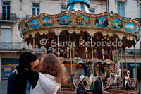 A couple kiss near a wheel located at one end of the Place de la Comedie. Around the Place de la Comedie, the heart of the city with numerous terraces and cafes, you can see performances by musicians and artists, festivals also contribute to its lively cultural and artistic life. Other advantages of this city are its Mediterranean climate, its proximity and good communications with Spain and its proximity to the Pyrenees and the famous Camargue region, with its long sandy beaches and lakes with flamingos wild colonies, ideal for people who love nature and outdoor excursions.   