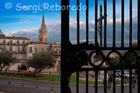 Boulevard du L. Vialleton con vistas de la iglesia de Saint Anne además de la cruz ubicada en la Place Giral.  Al norte se extiende el Jardin des Plantes –en 163 Rue Broussonet- el jardín botánico más antiguo de Francia, creado en 1593 para investigar los usos medicinales de las plantas ( tranvía 1: parada Place Albert 1er; martes a domingos de junio a septiembre de 12:00 a 20:00, de octubre a mayo de 12:00 a 18:00;  gratuito). A su lado se alza la austera Cathédrale Saint-Pierre, del siglo XV, cuyo enorme porte sobrevivió a los conflictos religiosos que asolaron la región en el siglo XVI (tranvía 1: parada Place Albert 1er;  de 9:00 a 12:00 y de 14:30 a 19:00). Regresando a la Rue Foch y dejando atrás el arco del Triunfo, a la derecha se extiende el barrio del antiguo Correo o Ancien Courrier.  La Place Sainte-Anne da acceso al Conservatorio de Música y a varios talleres de luthiers, desde cuyos ventanales puede observarse a los artesanos fabricar violines y guitarras. La Rue de l’Ancien Courrier es otra elegante arteria salpicada de palacetes medievales, en cuyos bajos se han instalado boutiques de lujo, que sirven de acceso a la romántica Place de Saint-Roch. Fue durante los siglos XVII y XVIII cuando los ricos mercaderes que se asentaron en la zona levantaron enormes mansiones de sobrio exterior, aunque con magníficos patios interiores.  Sobresalen el Hôtel St-Côme –en Grand Rue Jean Moulin- donde los estudiantes de la cercana Facultad de Medicina acudían a las primeras sesiones de anatomía y cuyas dependencias constituyen actualmente la Cámara de Comercio de Montpellier. En la misma calle se alza la Tour de Babote, una torre del siglo XII, que ha resistido las sucesivas transformaciones de la ciudad. El Hôtel des Trésoriers de la France –en 7 Rue de Jacques Coeur- es igualmente uno de los más destacables de Montpellier, con una preciosa arquitectura del siglo XV.