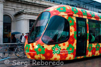 Un dels diferents tramvies de Montpeller. Montpeller és una ciutat francesa, a la costa mediterrània, a 200 km. de la frontera espanyola i a 700 km. de Saragossa. La seva àrea metropolitana és de 400.000 habitants, la meitat en el propi municipi. Compta amb una important universitat, atracció d'Erasmus espanyols, com Bordeus o Toulousse. La ciutat posseeix un elegant i animat centre històric al voltant d'una petita elevació sobre la resta de la ciutat, entre la Plaça de la Comédie i un petit parc, característic de les tres ciutats franceses vistes i tan escàs a Espanya, suposo que perquè els parcs no són comercials ni aparcables ni especulables. Montpeller va ser matinera a l'hora d'eliminar el tramvia, el 1949, i fins ni més ni menys que 46 anys després, no es decideix la seva rentrée. La línia 1 s'inaugura el juliol de 2002 entre Mosson i Odisseum, amb un recorregut de 15,2 km. atesos per 28 tramvies del tipus Citadis TGA 301, sent tal l'èxit que va ser necessari adquirir, gairebé immediatament, 2 vehicles més. Així mateix atesa la modularitat d'aquests vehicles va ser necessari allargar-des 30-40,5 metres. Va suposar la peatonalització de tot el centre de la ciutat, fent una obra molt significativa fins i tot de manera elevat per creuar la galeria comercial Antigone, en ple centre de la ciutat però amb components de hipermercat, i deixar expedita la Plaça de la Comédie, nucli central de la ciutat i per on passa la línia 1. La línia 2 s'inaugura al desembre de 2006 entre Saint Jean de Vedas i Jacou, amb una curiosa característica i és, que enfront del color blau de la línia 1, aquesta línia porta uns vehicles pintats de manera multicolor representant les flors, una de les seves produccions més típiques. Sense allunyar-se del centre, manté un traçat una mica més transversal que la primera. L'any 2012, està prevista la inauguració de la línia 3 de 22,4 km. i que arribarà fins a la zona de la platja. Les dades aportades el 2007 per la companyia explotadora parlen de 53,8 milions de viatgers, sense especificar quina part és pel tramvia, i un parc de 175 autobusos, encara que parlen d'un ús diari de 130.000 persones a la línia 1 de tramvia , la qual cosa estaria per sobre dels 30 milions de viatgers anuals, cosa que no em sorprendria per l'experiència personal que vaig tenir en visitar aquesta ciutat al setembre de 2007. Tramvia El tramvia de Montpeller és famós i fan referència als quatros elements: aire amb la línia 1, terra amb la línia 1, l'aigua amb la línia 3, el foc amb la línia 4 ... Les línies 3 i 4 estan dissenyades per Christian Lacroix.  pierresvives Pierresvives reuneix una biblioteca, un complex esportiu i oficines municipals i va ser dissenyat per Zaha Hadid.