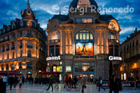 Place de la Comédie, a la qual es pot qualificar com a veritable centre de la ciutat. Una plaça àmplia, realment grandiosa i agradable tota ella envoltada dels típics edificis del segle XIX francès, en un extrem d'ella es troba el teatre de la comèdia que dóna nom a la plaça i en l'altre extrem, després de passar un agradable parc es troba un teatre modern amb arquitectura d'última generació. Des d'aquesta plaça pots anar a una zona comercial i moderna que és el Triangle, que enllaça primer amb el Polygone i finalment amb l'Ajuntament i el barri del Antigone. Atenció, Si segueix en peu la mateixa política que quan vaig estar per última vegada, al Polygone fora de l'horari comercial es pot aparcar per un preu ridícul, en aquella època un franc l'hora. Deixem de moment la zona de l'Antigone per desfer el camí i endinsar-nos en els carrerons del casc històric. Tot ell vianants, on s'alternen els carrers i places àmplies amb els carrerons i espais reduïts. El millor és expulsar i patejar per aquests carrers, perdre una i altra vegada fins que et sentis imbuït per l'esperit d'aquesta ciutat cosmopolita. Hi ha multitud de cases notables, hotels i edificis significatius a part d'algunes esglésies dignes de veure, se succeeixen els edificis de diferents èpoques històriques però amb un aspecte homogeni. Hi ha multitud de petits museus, algun molt interessant i visites organitzades a "hotels" històrics. Et pots informar de tot a l'oficina de turisme que es troba a la plaça de la comèdia, al costat del parc. Tot el centre està ple de restaurants de tot tipus i preu, alguns encantadors com li vieux Fourne o Le mex o el bodegó coloniel, etc. També hi ha diversos llocs per prendre copes fins a la 1:30 o 2:00 de la matinada que és quan comencen a tancar gairebé tot, prop de l'estació de tren també hi ha algun garito interessant, sobretot pels amants del rock. Per seguir la festa fins que surti el sol, cal desplaçar-se fins un polígon a l'entrada de la ciutat, on trobaràs discoteques i pubs, alguns d'ells amb terrasses d'estiu. Aquesta plaça històrica està envoltada de botigues i de cafès i de seguida us farà sentir l'ambient de la ciutat. Al centre de la plaça històrica trobareu la font de les Tres Gràcies, que va ser esculpida en 1790. La Opéra Comédie està situada a la cantonada sud-oest de la plaça, on podeu veure una òpera a la tarda. A la cantonada nord-est de la plaça trobareu un dels molts parcs de Montpellier: Esplanade de Charles de Gaulle. 