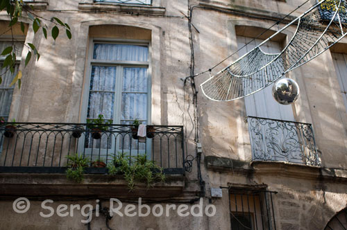 Balcons dels edificis més antics del casc antiuo de Montpeller. Aquí també s'inicia el gran mercat nadalenc que no té res a envejar als mercats de les ciutats alemanyes, fins i tot trobem el vi calent o mulled wine, més típic de l'Europa Central que d'una ciutat mediterrània, com tampoc poden faltar els creps, gofres i tot tipus de delicatessen. Per entrar en calor prenem una sopa de ceba, la sopa més deliciosa que mai he provat, per seguir amb un crèpe de xocolata negra al cointreau ... ummmm.El mercat de Nadal s'estén a través de l'àmplia Esplanade Charles de Gaulle fins l'Òpera Berlioz, l'altra Òpera de la ciutat, separada tan sols 400 metres de la primera el que demostra la gran afició per l'espectacle dels montpellerienses. En aquest mateix passeig, es troba el Museu Fabre, considerat un dels més importants museus de Belles Arts de França, amb obres de Rubens, Zurbarán o Delacroix entre d'altres. El seu nom fa honor al pintor François-Xavier Fabre que va néixer a Montpeller el 1825. Retrocedim de nou per la rue de la Loge i seguim per una altra de les principals avingudes del centre antic, la rue Foch, que desemboca a l'Arc de Triomf que a finals del segle XVII va ser manat construir per l'Administrador del rei en honor a Lluís XIV just en el lloc que ocupava una de les portes de l'antiga muralla.   