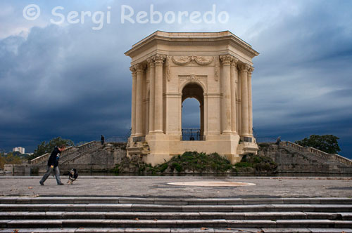 Torre de l'aigua a la Plaça Royale du Peyrou. Després de dinar en una de les terrasses d'un dels restaurants que hi ha en una de les places de la "rue de la Loge", ens dirigim cap a la "Rue Foch", amb destacats edificis del segle XIX i amb gran quantitat de "boutiques ". Al final del carrer Foch trobem l'Arc de Triomf, la Porta del Peyrou (1691), dissenyada en estil dòric amb relleus posteriors que glorifiquen el rei Lluís XIV de França. L'Arc de Triomf, uneix el carrer Foch amb el "parc Peyrou", un gran espai verd situat al cor del centre històric de Montpeller. A l'interior del Parc, a més dels jardins, destaquen l'estàtua eqüestre de Lluís XIV, "li château d'eau" (torre d'aigua) i "les Arceaux" (L'aqüeducte de Sant Climent - segle XVII-amb una longitud de 880m i dos ordres d'arcades, corre pel barri de Les Arceaux i es feia servir per portar l'aigua des de la font de Sant Climent, a 14 km de la ciutat). Sortim del parc Peyrou i busquem a l'esquerra el "Boulevard Henri IV" que ens permetrà arribar fins a la "Rue de l'Ecole de Médecine", on hi ha la "Faculté de Médecine". La Facultat de Medicina és la més antiga en activitat del món. A la pràctica existeix des del segle XII, encara que el seu primer marc institucional el va obtenir l'any 1220. Entre d'altres es van estudiar personatges il · lustres com ara: Nostradamus, François Rabelais, Arnau de Vilanova, o Ramon Llull.