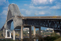 Puente de las Americas, Bridge of the Americas, Thatcher Ferry Bridge, Republic of Panama. The Bridge of the Americas (Spanish: Puente de las Américas; originally known as the Thatcher Ferry Bridge) is a road bridge in Panama, which spans the Pacific entrance to the Panama Canal. Completed in 1962, at a cost of US$20 million, it was the only non-swinging bridge (there are two other bridges, one at the Miraflores locks and one at the Gatun locks) connecting the north and south American land masses until the opening of the Centennial Bridge in 2004. The bridge was designed by Sverdrup & Parcel. 