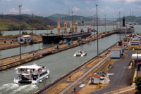 Gatún Bloqueo en el Canal de Panamá antes de diciembre 1999 Estados Unidos devolvió la soberanía a Panamá. Las esclusas del Canal de Panamá es un sistema de bloqueo que eleva un barco de hasta 85 pies (26 metros) a la fachada principal del Canal de Panamá y hacia abajo de nuevo. Cuenta con un total de seis pasos (tres arriba, tres abajo) para el paso de un barco. La longitud total de las estructuras de bloqueo, incluyendo los muros de aproximación, es más de 1.9 millas. Los bloqueos fueron una de las mayores obras de ingeniería en ser llevado a cabo cuando se abrió en 1914 Ninguna otra construcción de concreto de tamaño similar se llevó a cabo hasta que la presa Hoover, en la década de 1930.