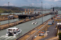 Gatun Lock in the Panama Canal December 1999 before United States returned sovereignty to Panama. The Panama Canal locks is a lock system that lifts a ship up 85 feet (26 metres) to the main elevation of the Panama Canal and down again. It has a total of six steps (three up, three down) for a ship's passage. The total length of the lock structures, including the approach walls, is over 1.9 miles. The locks were one of the greatest engineering works ever to be undertaken when they opened in 1914. No other concrete construction of comparable size was undertaken until the Hoover Dam, in the 1930s.