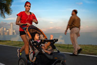 Funcionamiento de la mujer con su bebé en la Avenida Balboa carretera rascacielos malecón nuevo. Skyline, Ciudad de Panamá, Panamá, América Central. Cinta Costera Océano Cinta Costera del Pacífico Bahía de Panamá malecón parque lineal rascacielos moderno. Cinta Costera (Cinta Costera), Ciudad de Panamá, Panamá. Ciudad de Panamá es una ciudad en América Central, donde la congestión ha alcanzado un punto crítico. La ciudad está pasando por un período sin precedentes de estabilidad y las inversiones y hay gran cantidad de fondos públicos para proyectos de mejora de la infraestructura.