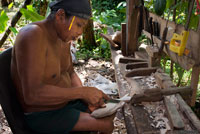 A men of The Ngobe Bugle Indian Village Of Salt Creek Near Bocas Del Toro Panama do wood souvenirs. Salt Creek (in Spanish: Quebrada Sal) is a Ngöbe Buglé village located on the southeastern end of Bastimentos island, in the Bocas del Toro Archipelago, Province and District of Panama.  The community consists of about 60 houses, an elementary school, handcrafts and general stores. The villagers depend mostly on their canoes for fishing and transportation although the village is slowly developing together with the whole archipelago. 