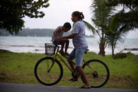 Mother with his kid in a bicycle. Bocas del Toro, Panama. Bocas del Toro (meaning "Mouth of the Bull") is a province of Panama. Its area is 4,643.9 square kilometers, comprising the mainland and nine main islands. The province consists of the Bocas del Toro Archipelago, Bahía Almirante (Almirante Bay), Laguna de Chiriquí (Chiriquí Lagoon), and adjacent mainland. The capital is the city of Bocas del Toro (or Bocas Town) on Isla Colón (Colón Island). Other major cities or towns include Almirante and Changuinola. The province has a population of 125,461 as of 2010.