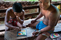 Playing Parcheesi in the village of the Native Indian Embera Tribe, Embera Village, Panama. Panama Embera people Indian Village Indigenous Indio indios natives Native americans locals local Parque National Chagres. Embera Drua. Embera Drua is located on the Upper Chagres River. A dam built on the river in 1924 produced Lake Alajuela, the main water supply to the Panama Canal. The village is four miles upriver from the lake, and encircled by a 129.000 hectare National Park of primary tropical rainforest. Lake Alajuela can be accessed by bus and mini-van