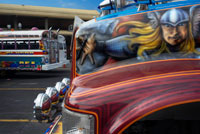 BUS RED DEVIL DIABLO ROJO PINTAT BUS PANAMÀ REPÚBLICA CIUTAT DE PANAMÀ. Terminal de l'estació d'autobusos Albrok. Panamà. Aquí ve el Diable Vermell, el bus de Xarxa Devil voladures seva botzina d'aire i cuejant al voltant d'un company "dimoni" just a temps per reclamar Irma Betancourt i altres viatgers del matí. Només cal dir els Diables Vermells guanyen el seu nom. "Estan bojos", va dir Betancourt, de 33 anys, una mestressa de claus en un hotel del centre, l'embarcament en un bulevard principal. "Tots sabem que. L'únic que importa és aconseguir la tarifa. Tantes vegades hem gairebé colpejar a algú".