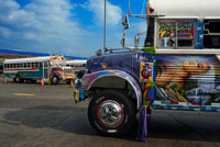 BUS RED DEVIL DIABLO ROJO PAINTED BUS PANAMA CITY REPUBLIC OF PANAMA. Albrok bus station terminal. Panama. Here comes the Diablo Rojo, the Red Devil bus blasting its air horn and fishtailing around a fellow “demon” just in time to claim Irma Betancourt and other morning commuters. Suffice it to say the Red Devils earn their name. “They are crazy,” said Ms. Betancourt, 33, a housekeeper at a downtown hotel, boarding on a main boulevard. “We all know that. All they care about is getting the fare. So many times we have almost hit somebody.”  Wandering around Panama City it’s hard to miss these crazy fuckin buses rolling around the city. Converted school buses are used as inexpensive public transportation. Each bus in the city is individually decorated which makes an interesting catch whenever rolling around. The average cost to ride one of these buses is 25 cents!  “Almost” may make her bus one of the lucky ones, as they are known to have taken more than a few souls for the sake of a pickup.  Her bus on a recent morning is like hundreds of others, a converted, cast-off American school bus ablaze with color, usually heavy on the red.  As if painted by a graffiti artist addicted to action movies and sports, they often boast fanciful, dreamy scenes, including, improbably, a looming Dumbledore from the Harry Potter movies glaring at Ms. Betancourt as she climbs aboard.