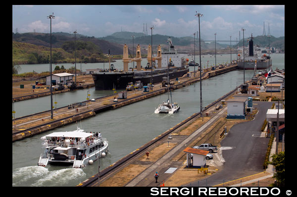 Gatun Lock in the Panama Canal December 1999 before United States returned sovereignty to Panama. The Panama Canal locks is a lock system that lifts a ship up 85 feet (26 metres) to the main elevation of the Panama Canal and down again. It has a total of six steps (three up, three down) for a ship's passage. The total length of the lock structures, including the approach walls, is over 1.9 miles. The locks were one of the greatest engineering works ever to be undertaken when they opened in 1914. No other concrete construction of comparable size was undertaken until the Hoover Dam, in the 1930s.  There are two independent transit lanes, since each lock is built double. The size of the locks limits the maximum size of ships that can transit the canal; this size is known as Panamax.  Construction on the Panama Canal expansion project began in September 2007. This will double the canal's capacity, allowing more and larger ships to use the canal. The project is expected to be completed in April 2015. The canal has three sets of locks. A two-step flight at Miraflores, and a single flight at Pedro Miguel, lift ships from the Pacific up to Gatun Lake; then a triple flight at Gatun lowers them to the Atlantic side. All three sets of locks are paired; that is, there are two parallel flights of locks at each of the three lock sites. This, in principle, allows ships to pass in opposite directions simultaneously; however, large ships cannot cross safely at speed in the Culebra Cut, so in practice ships pass in one direction for a time, then in the other, using both "lanes" of the locks in one direction at a time.