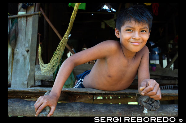 Boy en una casa en el Ngobe Bugle Indian Village Of Salt Creek Cerca de Bocas Del Toro Panamá. Salt Creek (en español: Quebrada Sal) es un pueblo Ngöbe Buglé se encuentra en el extremo sureste de la isla de Bastimentos, en Bocas del Toro Archipelago, Provincia y Distrito de Panamá. La comunidad se compone de unas 60 casas, una escuela primaria, artesanías y tiendas en general. Los aldeanos dependen principalmente de sus canoas para la pesca y el transporte, aunque el pueblo se está desarrollando lentamente junto con todo el archipiélago. Entre el Mar Caribe, con sus manglares, arrecifes de coral e islas paradisíacas, y el denso bosque húmedo tropical de la Isla Bastimentos, se encuentra la comunidad Ngobe conocido como Salt Creek (Quebrada Sal). Aquí, la ALIATUR organización local (Salt Creek Turismo Alliance) ha creado un proyecto para que los visitantes al archipiélago de Bocas del Toro pueden llegar a conocer la cultura de esta comunidad indígena, sus artesanías, sus bailes, y sus historias. Las medidas adoptadas para promover la sostenibilidad Cuatro senderos ambientales o sociales en los bosques de los alrededores permiten al turista apreciar la rica fauna y flora de la región. Alojamiento y comida típica de la zona se ofrecen para el que quiera visitar durante uno o más días en la comunidad de. En caso de que ésto no sea suficiente, la proximidad community's al Parque Nacional Marino Bastimentos permite a los turistas pagan una rápida visita a los maravillosos Cayos Zapatilla y para disfrutar de sus playas, arrecifes de coral, y el sendero.