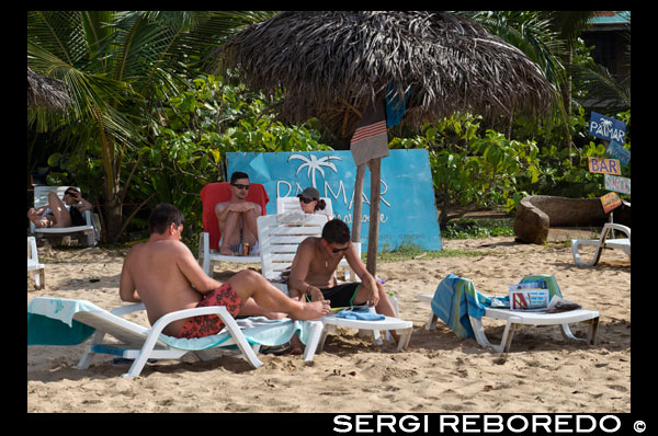 Turistas en Red Frog Beach. Bocas del Toro. Panamá. Alrededor de un 10 minutos en barco desde la ciudad de Bocas te lleva a la Marina Red Frog, desde donde una caminata de 15 minutos a través del punto de la Isla Bastimentos estrecha le permite llegar a Red Frog Beach. Con 0,75 kilómetros de arena blanca y dorada, Red Frog Beach es una de las playas más populares en Bocas del Toro. La costa norte de la Isla Bastimentos alberga algunas de las más hermosas playas de Bocas 'y Red Frog es uno de los más accesibles, y el único con unas instalaciones tales como un par de restaurantes y baños. Recibe su nombre de las ranas venenosas que son abundantes en colinas Bastimentos. Si tienes la suerte puede encontrarse con un perezoso de tres dedos o algunos monos también. Debido a su facilidad de acceso a muchas excursiones en barco que Red Frog Beach su última parada durante el día, que le proporciona un ambiente animado, con viajeros de todo el mundo (cualquier cosa entre 100 y 300 personas). Durante la temporada baja, que es mucho más tranquilo. Si le sucede a llegar a Red Frog y sentir la necesidad de más espacio para ti mismo siempre se puede caminar un poco hacia el este (Turtle Beach) o hacia el oeste en dirección a Playa Wizard (Playa Primera), o simplemente ir a otra playa en Bocas del Toro con menos gente ... hay un montón de playas en Bocas.