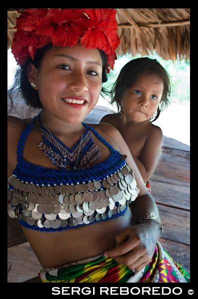 Retrato de mujer indígena embera y niño en el pueblo de la Native Indian Tribe Embera, Embera Village, Panamá. La gente de Panamá Embera Indian Village Indígena Indio Indios nativos americanos nativos lugareños locales Chagres Nacionales Parque. Embera Drua. Embera Drua se encuentra en la cuenca alta del río Chagres. Una presa construida sobre el río en 1924 produjo el Lago Alajuela, el suministro principal de agua para el Canal de Panamá. El pueblo está a cuatro kilómetros río arriba desde el lago, y rodeada por un parque nacional de 129.000 hectáreas de bosque tropical primario. Lago Alajuela se puede acceder en autobús y mini-van de la ciudad de Panamá. Se encuentra a una hora de la ciudad, cerca de la localidad de Las Cumbres. Desde un lugar llamado Puerto El Corotu (menos un puerto de un banco fangoso con una pequeña tienda que sirve como un muelle para embarcar y desembarcar de canoas) en la orilla del lago, se tarda 45 minutos a una hora para subir el Río Chagres a Embera Drua ina una piragua motorizada. El pueblo fue fundado en 1975 por Emilio Caisamo y sus hijos. Primero llamaron comunidad 2.60, ya que era el nombre de la estación meteorológica construida por la Comisión del Canal de Panamá ubicado un poco río arriba de la actual comunidad. Los hijos se casaron y trajeron a sus esposas a vivir en la comunidad que más tarde atrajo a más familias. La mayoría de los habitantes del pueblo se trasladó fuera de la Región de Darién - cada vez más peligroso debido a las incursiones de los guerrilleros colombianos y narcotraficantes - y para estar más cerca de la ciudad para tener un mejor acceso a sus servicios médicos y oportunidades educativas. En 1996, los pobladores adoptaron un nombre que refleja su identidad y comenzaron a llamar a su comunidad Embera Drua. En 1998, el pueblo sumó una población de 80 El liderazgo social y político del pueblo está dividido entre el Noko o jefe de la aldea, el segundo jefe, la secretaria, el contador y todos los comités. Cada comité tiene su presidente, y su contador, ya veces un secretario. Embera Drua tiene un comité de turismo que organiza itinerarios y actividades para grupos de visitantes y un comité de artesanos para ayudar a los artistas en la venta de sus cestas y tallas intrincadas. Dicha organización es un fenómeno relativamente nuevo, pero es inspirador ver cómo la comunidad ha abrazado. El pueblo de Embera Drua tiene su propia ONG. Sus objetivos son apoyar al pueblo y promover el turismo y sus artesanos. Gracias a sus esfuerzos, los pobladores de Embera Drua ahora poseen títulos de propiedad de sus tierras. Sus objetivos principales son ayudar al pueblo a convertirse en económicamente autosuficiente. La gente de la aldea de Parara Puru más abajo Chagres, se han unido a la ONG también. Si usted desea apoyar a su ONG, en contacto con ellos directly.The clima es tropical con dos estaciones bien diferenciadas. La temporada de lluvias dura alrededor de siete meses a partir de abril a octubre y la estación seca es de noviembre a marzo. La temperatura es bastante constante durante el año y varía desde los altos de 80 (alta C de 20) durante la mitad del día a los años 70 (C baja del 20) por la noche. El paisaje protege al pueblo de los fuertes vientos del invierno todavía mantiene bastante ventoso que el pueblo está casi libre de los insectos que pican.