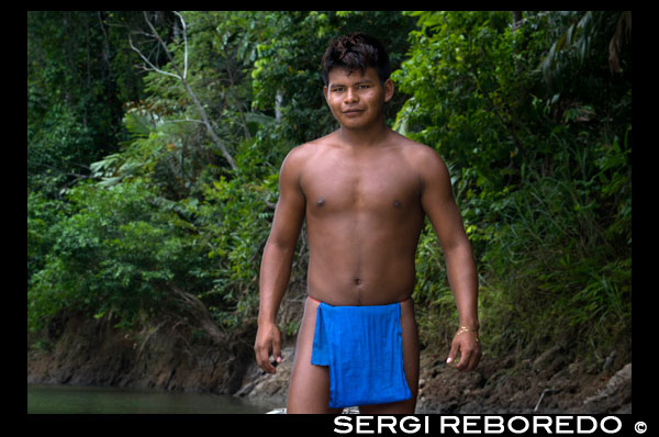 Retrato de nativos Embera Indian tribu. Los pobladores de la Native Indian Tribe Embera, Embera Village, Panamá. La gente de Panamá Embera Indian Village Indígena Indio Indios nativos americanos nativos lugareños locales Chagres Nacionales Parque. Embera Drua. Embera Drua se encuentra en la cuenca alta del río Chagres. Una presa construida sobre el río en 1924 produjo el Lago Alajuela, el suministro principal de agua para el Canal de Panamá. El pueblo está a cuatro kilómetros río arriba desde el lago, y rodeada por un parque nacional de 129.000 hectáreas de bosque tropical primario. Lago Alajuela se puede acceder en autobús y mini-van de la ciudad de Panamá. Se encuentra a una hora de la ciudad, cerca de la localidad de Las Cumbres. Desde un lugar llamado Puerto El Corotu (menos un puerto de un banco fangoso con una pequeña tienda que sirve como un muelle para embarcar y desembarcar de canoas) en la orilla del lago, se tarda 45 minutos a una hora para subir el Río Chagres a Embera Drua ina una piragua motorizada. El pueblo fue fundado en 1975 por Emilio Caisamo y sus hijos. Primero llamaron comunidad 2.60, ya que era el nombre de la estación meteorológica construida por la Comisión del Canal de Panamá ubicado un poco río arriba de la actual comunidad. Los hijos se casaron y trajeron a sus esposas a vivir en la comunidad que más tarde atrajo a más familias. La mayoría de los habitantes del pueblo se trasladó fuera de la Región de Darién - cada vez más peligroso debido a las incursiones de los guerrilleros colombianos y narcotraficantes - y para estar más cerca de la ciudad para tener un mejor acceso a sus servicios médicos y oportunidades educativas. En 1996, los pobladores adoptaron un nombre que refleja su identidad y comenzaron a llamar a su comunidad Embera Drua. En 1998, el pueblo sumó una población de 80 El liderazgo social y político del pueblo está dividido entre el Noko o jefe de la aldea, el segundo jefe, la secretaria, el contador y todos los comités. Cada comité tiene su presidente, y su contador, ya veces un secretario. Embera Drua tiene un comité de turismo que organiza itinerarios y actividades para grupos de visitantes y un comité de artesanos para ayudar a los artistas en la venta de sus cestas y tallas intrincadas. Dicha organización es un fenómeno relativamente nuevo, pero es inspirador ver cómo la comunidad ha abrazado. El pueblo de Embera Drua tiene su propia ONG. Sus objetivos son apoyar al pueblo y promover el turismo y sus artesanos. Gracias a sus esfuerzos, los pobladores de Embera Drua ahora poseen títulos de propiedad de sus tierras. Sus objetivos principales son ayudar al pueblo a convertirse en económicamente autosuficiente. La gente de la aldea de Parara Puru más abajo Chagres, se han unido a la ONG también. Si usted desea apoyar a su ONG, en contacto con ellos directly.The clima es tropical con dos estaciones bien diferenciadas. La temporada de lluvias dura alrededor de siete meses a partir de abril a octubre y la estación seca es de noviembre a marzo. La temperatura es bastante constante durante el año y varía desde los altos de 80 (alta C de 20) durante la mitad del día a los años 70 (C baja del 20) por la noche. El paisaje protege al pueblo de los fuertes vientos del invierno todavía mantiene bastante ventoso que el pueblo está casi libre de los insectos que pican.