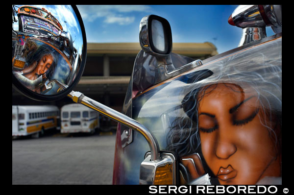 BUS RED DEVIL DIABLO ROJO PAINTED BUS PANAMA CITY REPUBLIC OF PANAMA. Albrok bus station terminal. Panama. Here comes the Diablo Rojo, the Red Devil bus blasting its air horn and fishtailing around a fellow “demon” just in time to claim Irma Betancourt and other morning commuters. Suffice it to say the Red Devils earn their name. “They are crazy,” said Ms. Betancourt, 33, a housekeeper at a downtown hotel, boarding on a main boulevard. “We all know that. All they care about is getting the fare. So many times we have almost hit somebody.”  Wandering around Panama City it’s hard to miss these crazy fuckin buses rolling around the city. Converted school buses are used as inexpensive public transportation. Each bus in the city is individually decorated which makes an interesting catch whenever rolling around. The average cost to ride one of these buses is 25 cents!  “Almost” may make her bus one of the lucky ones, as they are known to have taken more than a few souls for the sake of a pickup.  Her bus on a recent morning is like hundreds of others, a converted, cast-off American school bus ablaze with color, usually heavy on the red.  As if painted by a graffiti artist addicted to action movies and sports, they often boast fanciful, dreamy scenes, including, improbably, a looming Dumbledore from the Harry Potter movies glaring at Ms. Betancourt as she climbs aboard.  Reggaetón, salsa and other bass-heavy music concuss the air, to attract riders to the privately owned buses. Growling mufflers contribute to the soundtrack of the streets. And no self-respecting grille lacks a wild string of Christmas lights.  Typical fare: 25 cents.  “They evolved into the most visually dominant aspect of Panama City,” said Peter Szok, a professor at Texas Christian University in Fort Worth who has studied the buses and the folk art of Panama.  It is a tradition elsewhere in the region as well, in other Panama cities as well as in countries like Suriname, where the buses are adorned with politically tinged portraits of heroes and outlaws. But here, at least, the ride is coming to an end.  The buses, many of them retired from Florida schools, have been the backbone of public transit here for more than four decades, with the tradition of decorating vehicles used for public transportation going back even further. Mr. Szok traces the art form to a desire to reflect Latin music styles and an idealized life.  Panama City, however, is rapidly modernizing, with a towering skyline and sprawling shopping malls that promoters hope will put it on the map as another Singapore.  With that has come a push for order. A subway is being dug. Roadways are being built or planned. The Red Devils, owned and operated by their drivers with no real set schedule, are being phased out in favor of something decidedly more vanilla and benign, a Metro Bus system with generic boxy white vehicles familiar in any cities. The only dash of a color is an orange slash.  “Safe, comfortable, reliable,” is the slogan. There is even a route map.  President Ricardo Martinelli, whose administration has championed the new system, has pointed to the new buses as a sign of progress, blaming the Red Devils for accidents and accusing them of unreliable service.  “They will race from one end of the city to the other, killing people, killing themselves,” he said in a speech in Washington in April. “Yeah, a lot of people were killed.”  But the Metro Buses, too, are drawing complaints, mainly for slow service. The 25-cent fare on most routes is expected to rise to 45 cents next year, and is already drawing grimaces. Some have taken to calling them the Diablos Blancos, the White Devils.  “Hey! The line starts back there,” several people shouted at one crowded downtown Metro Bus stop as their ride finally arrived in a downpour.  “Look at this long line and little bus shelter,” said David Polo, 33, who had been waiting for more than 20 minutes. “The new buses may be safer, but they need more of them.”  Panama’s transportation officials said the Red Devils, numbering about 1,200 in recent years, would be gone by the end of this year, but the plan has been delayed more than once as the new system seeks to hire and train drivers.  As the Red Devils disappear — some of them, in the ultimate twist of fate, converted back to school buses, and others dismantled for scrap or sitting in bus boneyards — something a bit unexpected has emerged.  Sympathy for the Red Devils.  The nostalgia ranges from the tongue in cheek — a “Save the Diablo Rojo” YouTube video purports to mourn the end of tourists’ losing their wallets, among other things, on them — to genuine regrets.  “It is a loss of part of our culture,” said Analida Galindo, a co-director of the Diablo Rosso art gallery in the historic Casco Viejo neighborhood. Yes, the gallery name is a play on the Red Devils’ name.  The gallery sells bus doors painted by one of the more prolific Red Devil artists, Oscar Melgar, for $2,500 (no takers yet).  Mr. Szok said the painters were largely self-taught, many of them the sons of West Indian immigrants, though some in later years had gone to art school. They typically charged $2,000 and up to paint the buses, meaning some are a kaleidoscope of images while, in others, the yellow has been barely painted over, depending on the wherewithal of the driver.  “It was a great tradition that people are going to miss,” said one of the painters, Ramón Enrique Hormi, known as Monchi. “Here it is Christmastime, and what am I going to do? I have nothing.”  Some owners, too, have complained that the $25,000 that the government is offering them in compensation for giving up their buses may sound generous but will not carry them very far.  Several drivers said they could not get jobs with Metro Bus because of their poor driving records, though the new system has hired many Red Devil drivers.  Other drivers said they had long held second jobs and would find other work.  “Everything has to come to an end someday,” one driver, Juan Estanciola, said on a recent day outside his modestly painted bus, which is mostly white with purple trim and bears sayings like “Don’t let my presence mess with your mind.”  He spoke at the door of his bus, which had just collided with a taxi on a rainy afternoon.  “It was his fault,” he said. “He cut in front of me. They don’t know how to drive.”