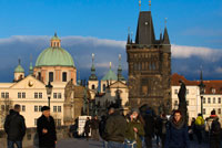 Vistas de la Iglesia de San Nicolás desde el Puente de Carlos.  La Torre de la Iglesia de San Nicolás es una de nuestras preferidas de Praga, la subida es emocionante y tiene varias salas a medio camino que pueden ser visitadas. En estas salas aprenderéis mucho sobre la historia de las campanas y sus diversas funciones. Igual que el Castillo de Praga, las torres del Puente de Carlos y el Ayuntamiento de la Ciudad Vieja, la iglesia de San Nicolás también forma parte indispensable del panorama de Praga. Una de las construcciones barrocas más bellas de Europa corona el barrio Malá Strana desde hace más de tres siglos, siendo el lugar que admira diariamente multitud de personas de todo el mundo. ¡Ríndase usted también ante su belleza y grandiosidad barrocas! 