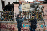 Una parella en el pont dels enamorats. Praga. No és tan ostentós ni conegut com el gran pont de Carles, però als habitants de Praga els encanta aquest petit i bonic pont enreixat, gairebé camuflat en la part menys coneguda del nucli antic i que amb només 20 metres és capaç de creuar amb extrema confiança ni més ni menys que el Canal del Diable. L'antic pont del Priorat, on encara avui es pot veure la vella roda del molí, disposa d'follet de l'aigua i des de fa uns anys és el lloc més buscat pels enamorats per tancar els seus cadenats en ensenyar d'amor etern.