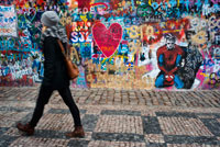 Una noia passa al costat del Mur de John Lennon al centre de Praga. El Mur de John Lennon és una paret, que al seu dia va ser una més de les que es podien trobar en qualsevol dels edificis del barri de Malá Strana a la capital de la República Txeca: Praga, però que des de principi dels anys 80 rep aquest nom en ser contínuament decorada amb nous graffities inspirats en la figura de John Lennon i amb trossos de cançons dels Beatles. El mur es troba situat a la plaça Velkop? Evorské nám? Sti, davant del palau Buquoy que alberga l'ambaixada francesa i és propietat dels cavallers d'Ordre la Creu de Malta que permeten que se segueixin pintant ininterrompudament nous graffities en el mateix.