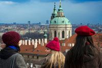 Vistas de la Iglesia de San Nicolás y del Barrio de Mala Strana desde el Castillo de Praga.  Perderse por Mala Strana, al caer la tarde un mes de invierno, es disfrutar de una experiencia única en Praga. La tenue luz de sus calles, el alumbrado público del barrio ayuda, y mucho, al ambiente, es retroceder al pasado, imaginarse cabalgando por sus calles y oir el estruendo de los cascos de un caballo sobre los adoquines. 