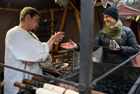 A woman buys delicious trdelník at a street stall. One of the sweets are trdelník Prague. Some cupcakes rolled and hollow, plated sugar, flour, nuts and cinnamon. In this position made ??them great. Trdelník (also known as Skalicky trdelník) is a cake tradicioal of Slovak cuisine (on the border of Slovakia and Moravia) .1 This is a rolled dough on a wooden skewer (whose name is Trdlo) and handle (Rotisserie) a charcoal fire while rotating mass on itself. The final form is that of a fire massecuite cylindrical and hollow inside, slightly smoky flavor with cinnamon and aromatzado. It is very traditional in street markets (in Prague), and is usually served as street food. Markéta Lehecková.