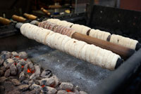 Puesto callejero de Trdelník. El Trdelnik es una masa de harina, azúcar, huevo, levadura, canela y leche que se estira y se enrolla en un palo de madera (Trdlo) o metal. Se pasa por una mezcla de azúcar con nueces finamente picadas y se coloca a asar en las brasas, girando sobre sí mismo, hasta que está dorado. Queda un dulce de forma cilíndrica y hueco. Tiene un liguero sabor ahumado y un agradable sabor a canela. Se pueden probar en muchos de los puestos callejeros que nos encontramos por Praga, incluso por algunos de Viena o de Budapest. El Svarené Víno también lo encuentras en los puestos de Praga. Las calles se impregnan de ese rico olor a clavo, canela y vino. Ayuda a sobrellevar las bajas temperaturas gracias al calorcito que te transmite a las manos y al estómago… Digamos que el poquito alcohol que lleva también hace su trabajo. Me recuerda al vino que hacemos en las recreaciones medievales. Ellos bebían el Ypocras o Hipocrás. 