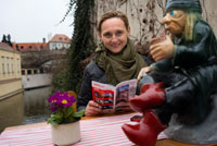 Cafetería junto al puente de los enamorados.  El puente de los enamorados (el antiguo puente del molino del Gran Prior) es el más antiguo que atraviesa el canal del Diablo en Praga. No es muy grande, tiene solo 20,5 m de longitud y 4,3 m de ancho. Através de su rejita se puede ver todavía la rueda del antiguo molino y una estatua de "vodník". Vodník o sea el hombre del agua es típico personaje de los cuentos checos de ni?os en los que representa el mal igual que las brujas. Pero la vista hacia la rueda y el vodník cada vez es más difícil por la cantitad de candados que las personas vienen poniendo en la reja. A ¿qué se debe esta acción? Esta tradición es originaria de China donde al lado de la Gran Muralla China se ponían cuerdas en las que los recién casados solían poner candados cuyas llaves después tiraban através de la muralla para asegurarse el amor eterno y la felicidad. 