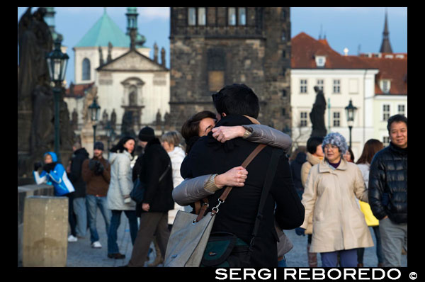 Una pareja se besa apasionadamente en el Puente de Carlos.  El Puente de Carlos (en checo Karl?v most) es el puente más viejo de Praga, y atraviesa el río Moldava de la Ciudad Vieja a la Ciudad Pequeña. Es el segundo puente más antiguo existente en la República Checa. A lo largo de su historia, el Puente de Carlos fue testigo de numerosos acontecimientos, al tiempo que sufrió daños en varias ocasiones. En 1432, una inundación destruyó tres de sus pilares. En 1496, el tercer arco (contando desde el lado de la Ciudad Vieja) se desplomó luego de que uno de los pilares descendiera debido a la erosión en su parte inferior. En esta ocasión, los trabajos de reparación duraron hasta el año 1506. Un año después de la Batalla de la Montaña Blanca, luego de la ejecución de los 27 líderes de la revuelta anti-Habsburgo el 21 de junio de 1621, las cabezas de los rebeldes fueron expuestas en el puente para disuadir a los checos de la posibilidad de nuevos alzamientos. Hacia fines de la Guerra de los Treinta Años, en 1648, los suecos ocuparon la ribera occidental del Moldavia y en su intento de avanzar hacia la Ciudad Vieja, la batalla más importante se produjo sobre el puente. Durante el combate, la torre del lado de la Ciudad Vieja sufrió graves daños en uno de sus lados (el que mira hacia el río) y la mayor parte de los ornamentos góticos debieron ser retirados. Durante el siglo XVII y principios del XVIII el puente adquirió la apariencia por la cual se lo reconoce ahora, al instalarse una serie de estatuas barrocas sobre los pilares del mismo. Durante una gran inundación ocurrida en 1784, cinco pilares fueron dañados considerablemente y, si bien los arcos no se rompieron, el tránsito por el puente debió ser restringido por un tiempo. 