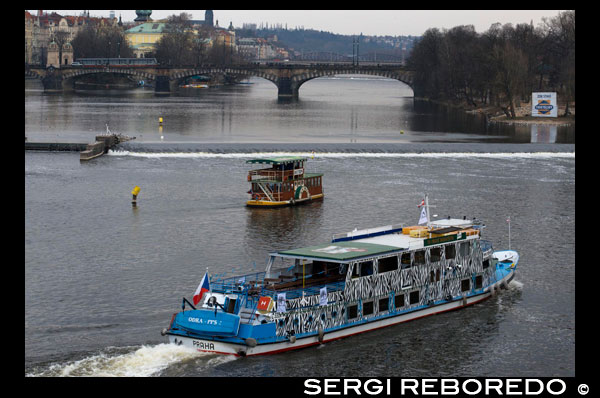 Passeig en vaixell pel riu Moldava. Un passeig pel riu Moldava és una activitat que no hauria de faltar en un viatge a Praga. Trobareu passejos en vaixells a totes hores i per a totes les butxaques. Hi ha molts tipus de recorreguts amb vaixell per Praga: des de petits passejos per veure la ciutat des del riu, fins a creuers diürns i nocturns amb menjar i sopar. Si voleu tenir una vetllada perfecta podeu optar per un passeig amb sopar i música en viu, veure Praga il · luminada des de l'Moldava i gaudir d'un bon sopar sempre és un encert. On contractar els passejos? La millor manera d'estalviar temps de cues i poder fer el passeig quan vulgueu és fer la reserva per internet. Hem aconseguit un acord amb l'agència més important de Praga per poder oferir excursions amb un petit descompte: Passeig en vaixell amb sopar i música en directe: Aquest és el passeig estrella a Praga. Per només 30 € podreu gaudir de 3 hores de navegació, un sopar bufet i música en viu. Creuer d'una hora amb comentaris en espanyol: El passeig d'una hora és una bona forma de conèixer Praga des del riu. Els preus són de 9 € per adult i 4 € per nen. El riu Moldava és el riu més llarg de la República Txeca amb 430 quilòmetres. El seu naixement està en les fonts d'Šumava i al llarg del seu curs s'uneix amb el riu