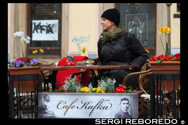 Café Kafka en el centro de Praga. El Callejón del Oro es una calle corta, estrecha y preciosa situada en el interior del Castillo de Praga. Debe su nombre a los orfebres que la habitaron en el siglo XVII. Callejón del Oro El lado izquierdo está ocupado por casitas de colores que fueron construidas en los muros del castillo. Estas casas se construyeron a finales del siglo XVI con el proposito inicial de dar cobijo a los 24 guardianes del castillo. Un siglo después de ser construidas, el gremio de los orfebres ocupó las casas y las modificó. Habitaron en ellas varios siglos. Hacia el siglo XIX fueron habitadas por mendigos y delincuentes de Praga. En el siglo XX fueron desalojados y las casas se han convertido en tiendecitas de marionetas, cristal y otros productos típicos.  La casa de Franz Kafka El Callejón del Oro es especialmente conocido porque en la casa número 22 vivió Franz Kafka, uno de los escritores más influyentes del siglo XX, entre 1916 y 1917.  No te lo pierdas El Callejón del Oro te sorprenderá, no te lo pierdas y aprovecha la oportunidad para entrar al mayor número de casas posibles. A nosotros nos gustaron especialmente las tiendas de marionetas y las de armaduras y armas medievales. En la tienda de armas podréis disparar una ballesta (y llevaros la diana de recuerdo). Markéta Lehecková. 