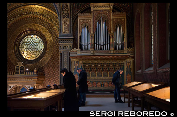 Museo Judio de Praga.  Sinagoga española. La sinagoga más espectacular Sin lugar a dudas, la sinagoga más espectacular del barrio judío de Praga. Construida en 1868 en el sitio de la sinagoga más antigua de Praga (la Vieja Escuela), adquiere el nombre de "La Española" debido a su decoración morisca, de gran similitud a La Alhambra de Granada. Puede visitarse todos los días excepto los sábados, a partir de las 9:00 h. Hasta las 18:00 h, en verano, y las 16:30 en invierno (no se vende entrada individual para esta sinagoga, hay que comprar entrada conjunta para todas las sinagogas, unos 20 euros). Otras sinagogas a visitar en Praga son klausen y Pinkas. Sinagoga española de Praga Si bien el exterior no es demasiado atractivo, aunque sí chocante por sus aires moriscos, el interior descubre una joya en medio de los grandes edificios que la rodean. Aparte de techos y paredes decoradas maravillosamente, el templo nos muestra libros, registros y fotografías de la comunidad judía en Praga y durante el Holocausto. En otra sala se expone la colección de instrumentos sagrados como coronas de la Torá o punteros, todos ellos en plata. Por fuera nos espera una escultura en homenaje a Franz Kafka. Una visita que no puedes perderte Una de las visitas que no puedes perderte el día que recorras el barrio judío de Praga es la Sinagoga Española. Su nombre proviene de los judíos que se refugiaron en ella después de ser expulsados de España por los Reyes Católicos. Tiene una colección de tejidos sagrados procedentes de toda Europa realmente importante. Realmente su encanto se encuentra en el interior, con una decoración recargada. El edificio es también muy bonito pero bastante mas austero y de estilo morisco.  Esta situada en el lugar en el que estaba situada la primera sinagoga de Praga. Además en esta sinagoga se celebran conciertos de música clásica en un entorno privilegiado. La más bonita de las sinagogas En el barrio judío podemos visitar varias sinagogas, pero sin duda la que más me gustó fue la sinagoga Española, y no porque tirara la tierra, si no porque el interior fue de los que más me sorprendió, con un estilo morisco que recuerda a la Alhambra de Granada. Justo al lado de la sinagoga está la estatua de Frank Kafka, la persona más famosa de este barrio. En el interior está prohibido hacer fotos. 