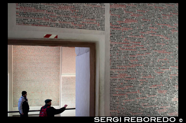 Els noms de les víctimes a les parets de la Sinagoga Pinkas . La sinagoga Pinkas del segle XV , anomenada així en honor del seu fundador , el rabí Pinkas , està localitzada just darrere de l'entrada al Vell Cementiri Jueu de Praga . La sinagoga Pinkas està dedicada a les víctimes jueves de l' Holocaust , procedents de Bohèmia i Moràvia : els seus noms estan inscrits en les parets de la nau principal i zones annexes . El text de les inscripcions va ser compilat de diferents arxius , a partir dels documents de transport , llistes de registre i declaracions dels supervivents . Les inscripcions comprenen els noms de les víctimes , el seu lloc de naixement i el lloc de la seva mort , en els casos en què s'ignora la data de la defunció ( en molts casos ) , està inscrita la data de la deportació als ghettos i camps d'extermini , generalment l'última informació que tenim de les víctimes . Els noms estan agrupats segons les ciutats i pobles en els quals vivien abans de la deportació o arrest , i estan presentats en ordre alfabètic : la nau principal agrupa tots aquells la última adreça era la de Praga , la resta de l'espai interior commemora a les víctimes de fora de la ciutat . A banda i banda de l'Arc Sagrat estan gravats els noms dels ghettos i camps de concentració on els jueus bohemis i moravos van ser deportats i , en molts casos , exterminats . Des de 1954 a 1959, la sinagoga Pinkas va ser transformada en un memorial per als jueus de Bohèmia i Moràvia . Durant aquest període , van ser gravats els noms dels 80.000 jueus de Bohèmia i Moràvia que van ser perseguits i assassinats en l'Holocaust . En 1968, la sinagoga va ser clausurada , perquè es van produir inundacions en els seus fonaments , fent perillar l'edifici i danyant la seva estructura . Durant els treballs de restauració van ser trobades diverses instal · lacions antigues . El règim comunista va frenar deliberadament els treballs de restauració i les inscripcions amb els noms dels assassinats durant l'Holocaust van ser retirades . No va ser possible completar la restauració de l'edifici fins a 1990 , i entre 1992 i 1994 es van tornar a gravar els noms dels jueus de Bohèmia i Moràvia morts durant l'Holocaust . El 1994 , la sinagoga Pinkas , així com el Museu Jueu , que està estretament relacionat amb la sinagoga , van rebre un suport independent de l'Estat . A partir de 1996 va ser completada la tasca de tornar a inscriure els noms dels jueus assassinats a les parets de la sinagoga Pinkas . La sinagoga va ser severament danyada durant les inundacions de l'estiu de 2002 , i no va ser reoberta fins a agost de 2004 , després d'un extens treball de restauració . Aquest memorial és un llarg epitafi que commemora els noms d'aquells per a qui no ha pogut erigir una làpida . Les víctimes de l' Holocaust també són commemorades en una exposició permanent de dibuixos de nens procedents de Terezín que , des de maig de 1997, està allotjada al pis superior de la sinagoga . La història dels nens deportats a Terezín és descrita en 19 seccions a l'habitació adjacent a la galeria del pis superior . La història està descrita a partir dels dibuixos dels nens realitzats en Terezín entre 1942 i 1944 , i que van ser duts a terme durant les classes organitzades per Friedl Dicker - Brandeis ( 1898-1944 ) , una pintora i dissenyadora d'interiors , també internada en el ghetto . Com a part d'un programa d'educació essencialment clandestina per als nens de Terezín , les classes d'art es van convertir en elements de gran importància en la vida diària del ghetto . Aquestes classes van funcionar com una mena de teràpia per als nens, que els va ajudar a suportar la vida al ghetto . Abans de la seva deportació a Auschwitz , Dicker va omplir dues maletes amb més de 4.500 dibuixos de nens i els va amagar . Van ser recuperats immediatament després de la guerra i portats al Museu Jueu de Praga. S'han convertit en un recordatori del tràgic destí dels jueus durant la Segona Guerra Mundial . Només uns pocs d'aquests nens de Terezín sobreviure a la guerra : la immensa