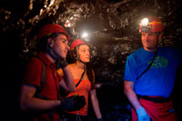 Aymeric. Tourists exploring the underground caves created by lava in the Grand Brûlé. Cooling and crystallization of basaltic lava around the sides, bottom and top channels lava rock produces a coated conduit called a lava tube. Crystalline basalt remains relatively hot surrounds and insulates washed inside the washing tube over crystallization. The tube provides a very efficient mechanism of basaltic lava flows that travel long distances away from their source, without significant heat loss. Lava tubes are typically <1 km long, it may exceed several kilometers. The diameters of the lava tubes are also highly variable, from <1 m up to 15 m. Flow inside lava tubes in Hawaii were recorded at 35 mph. Fast moving, turbulent lava, combined with the high temperatures of lava, may result in thermal erosion inside the tube.